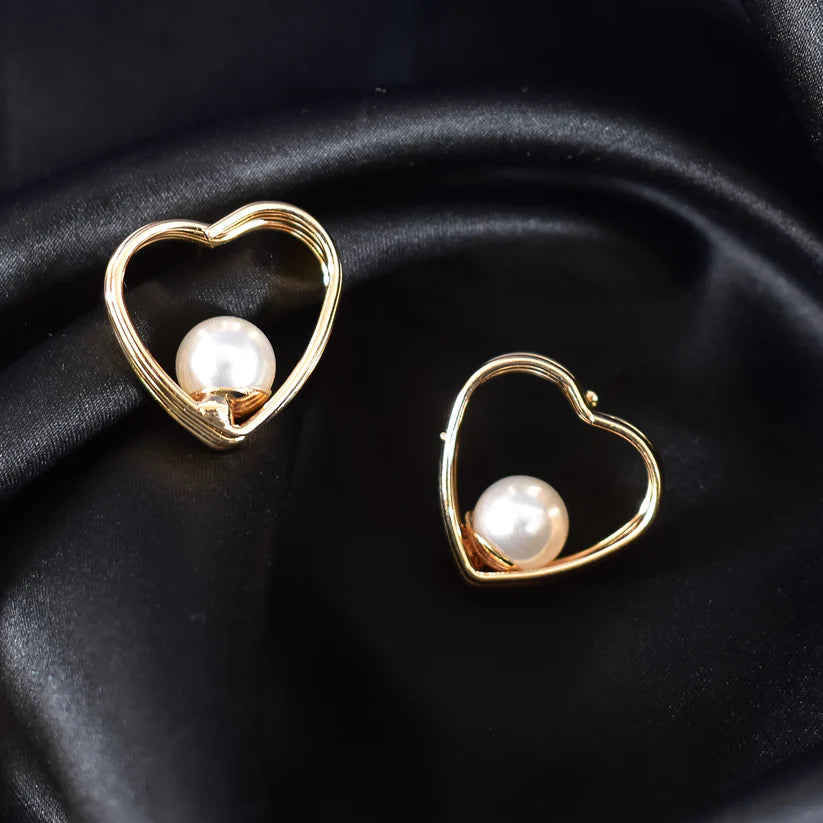 This is a gold heart-shaped earring with a pearl centerpiece. I’ll create a luxury-style product description for your store: