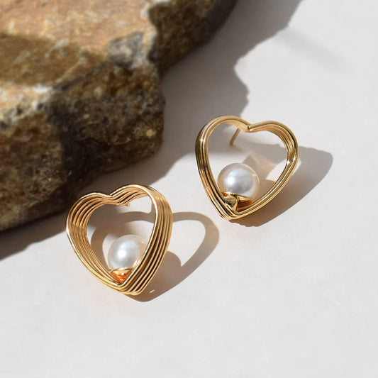 This is a gold heart-shaped earring with a pearl centerpiece. I’ll create a luxury-style product description for your store: